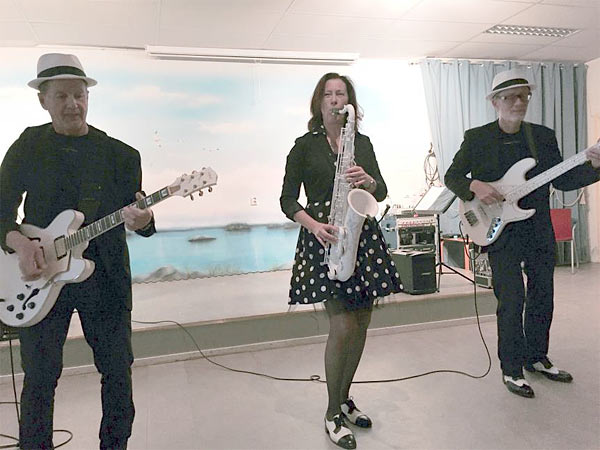 Monika med en vacker vit tenorsaxofon, Sven-Erik Larsson med gitarr och sång och Christian Veltman med bas. 
